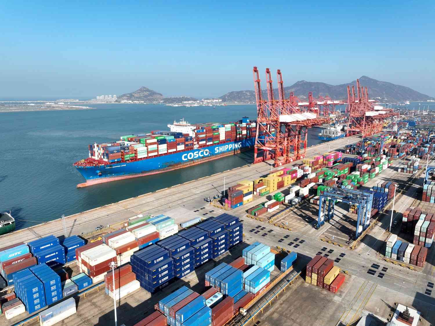 Container ship being loaded at an ocean terminal, the freight leg that drives imported flooring cost